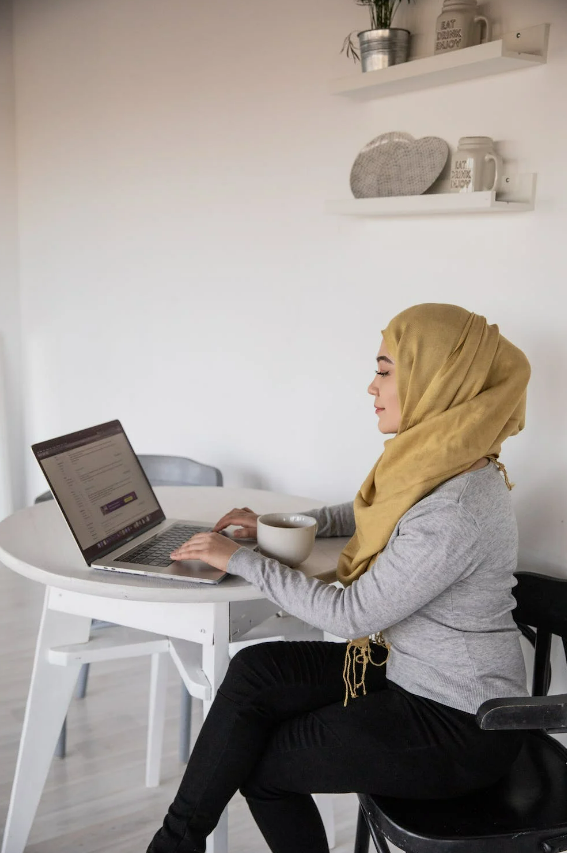 Woman sitting at laptop in her home